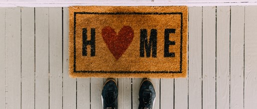 A doormat that says "Home" with a love heart replacing the O