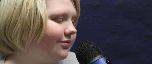 A young person addressing a microphone